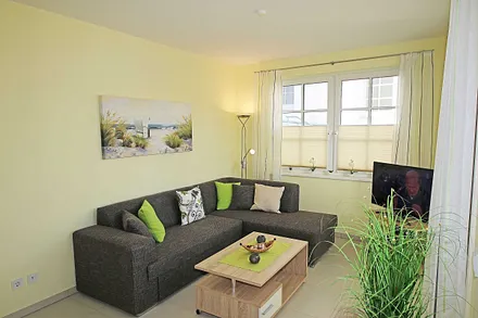 Wohnbereich mit vollwertiger Schlafcouch mit Ottomane (Aufbettung 3. Person, 1,25m x 2,00m), Couchtisch, Leselampe, Smart-TV, Blu Ray Player, Mini-Stereo-Anlage und Insektenschutzgitter