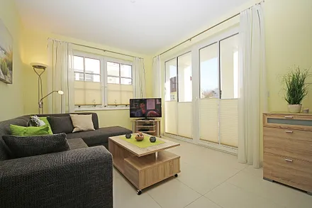 Wohnbereich mit vollwertiger Schlafcouch mit Ottomane (Aufbettung 3. Person, 1,25m x 2,00m), Couchtisch, Leselampe, Smart-TV, Blu Ray Player, Mini-Stereo-Anlage und Insektenschutzgitter