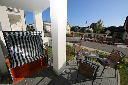 überdachte und bestuhlte Terrasse (Süd/Ost) mit einem Strandkorb