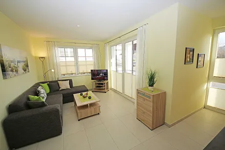 Wohnbereich mit vollwertiger Schlafcouch mit Ottomane (Aufbettung 3. Person, 1,25m x 2,00m), Couchtisch, Leselampe, Smart-TV, Blu Ray Player, Mini-Stereo-Anlage und Insektenschutzgitter