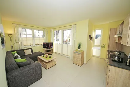 Wohnbereich mit vollwertiger Schlafcouch mit Ottomane (Aufbettung 3. Person, 1,25m x 2,00m), Couchtisch, Leselampe, Smart-TV, Blu Ray Player, Mini-Stereo-Anlage und Insektenschutzgitter