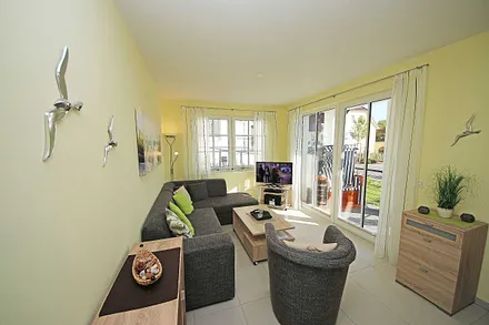 Wohnbereich mit vollwertiger Schlafcouch mit Ottomane (Aufbettung 3. Person, 1,25m x 2,00m), Couchtisch, Leselampe, Smart-TV, Blu Ray Player, Mini-Stereo-Anlage und Insektenschutzgitter