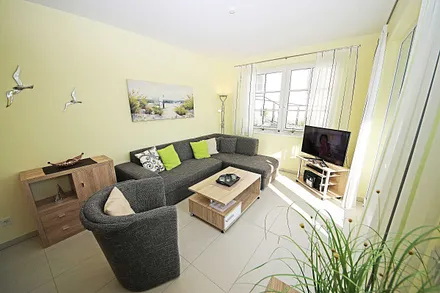 Wohnbereich mit vollwertiger Schlafcouch mit Ottomane (Aufbettung 3. Person, 1,25m x 2,00m), Couchtisch, Leselampe, Smart-TV, Blu Ray Player, Mini-Stereo-Anlage und Insektenschutzgitter