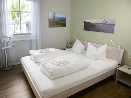 Schlafzimmer mit Doppelbett (1,80m x 2,00m), 2 Nachttischkonsolen, Flachbildschirm-TV-Gerät, Insektenschutzgitter und ein Kleiderschrank