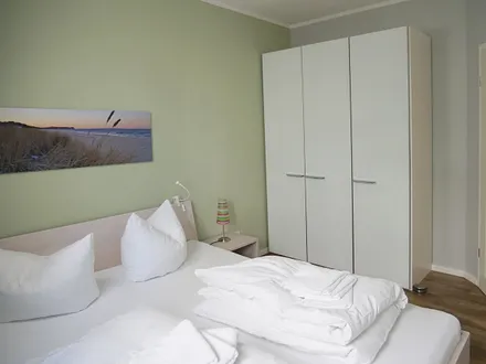 Schlafzimmer mit Doppelbett (1,80m x 2,00m), 2 Nachttischkonsolen, Flachbildschirm-TV-Gerät, Insektenschutzgitter und ein Kleiderschrank