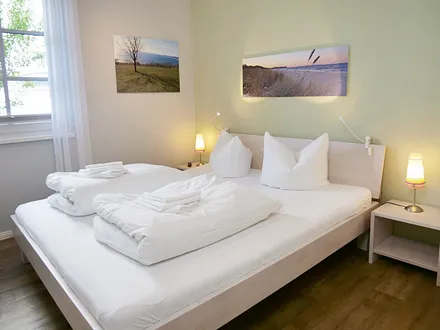 Schlafzimmer mit Doppelbett (1,80m x 2,00m), 2 Nachttischkonsolen, Flachbildschirm-TV-Gerät, Insektenschutzgitter und ein Kleiderschrank