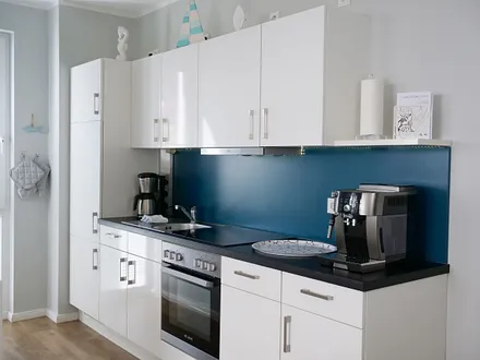 Einbauküche mit 4-Zonen-Cerankochfeld und Backofen, Kühlschrank mit 3*-Gefrierfach, Toaster, Wasserkocher, Geschirrspülmaschine, Kaffeemaschine mit Thermoskanne sowie einen Delongi Kaffeevollautomat  