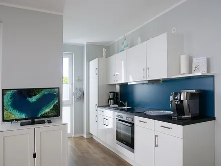 Einbauküche mit 4-Zonen-Cerankochfeld und Backofen, Kühlschrank mit 3*-Gefrierfach, Toaster, Wasserkocher, Geschirrspülmaschine, Kaffeemaschine mit Thermoskanne sowie einen Delongi Kaffeevollautomat  