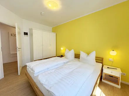 Schlafzimmer mit Doppelbett und Kleiderschrank