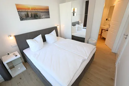 erstes Schlafzimmer mit Kleiderschrank und kleinem Bad