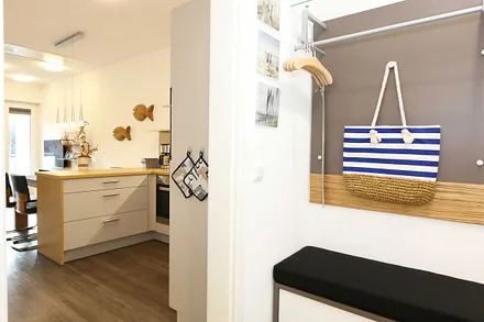 heller Flur mit Garderobe, Sitzgelegenheit und bodentiefem Spiegel