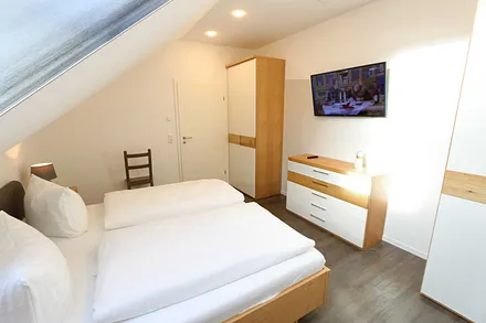Schlafzimmer mit Doppelbett und TV