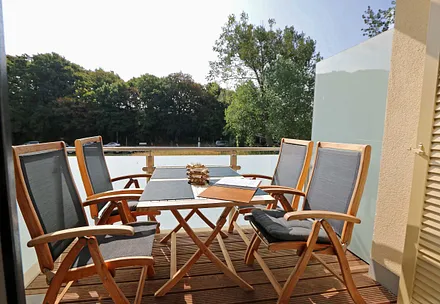 Bangkirai belegter, windgeschützer Südbalkon mit Teakholz-Sitzgruppe, Insektenschutzgitter und Sonnenschirm