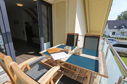 Bangkirai belegter, windgeschützer Südbalkon mit Teakholz-Sitzgruppe, Insektenschutzgitter und Sonnenschirm