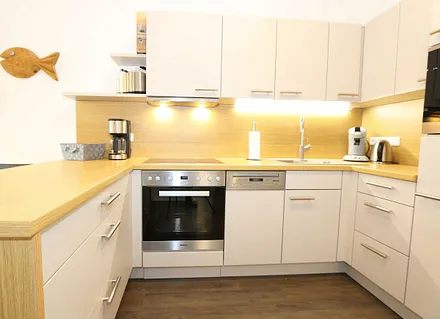 Küchenzeile mit Mikrowelle, Backofen, Induktionskochfeld, Geschirrspüler, Kaffeemaschine, Pad-Maschine (Senseo), Wasserkocher, Eierkocher, Toaster, Handmixer und Kühlschrank mit Gefrierfach 