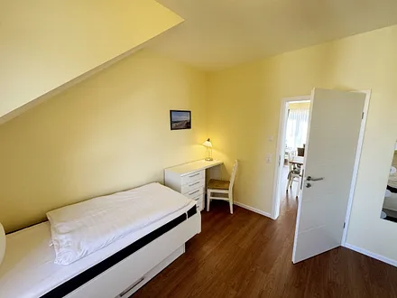 Schlafzimmer mit zwei Einzelbetten (0,90 m x 2,00 m), Nachttischablagen, Garderobenschrank und Schreibtisch