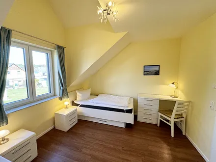 Schlafzimmer mit zwei Einzelbetten (0,90 m x 2,00 m), Nachttischablagen, Garderobenschrank und Schreibtisch