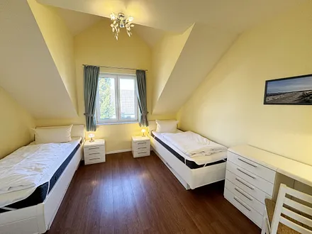 Schlafzimmer mit zwei Einzelbetten (0,90 m x 2,00 m), Nachttischablagen, Garderobenschrank und Schreibtisch