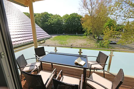 bestuhlter Südbalkon mit Sonnenschirm - vom Wohnbereich begehbar