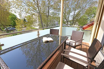 bestuhlter Südbalkon mit Sonnenschirm - vom Wohnbereich begehbar