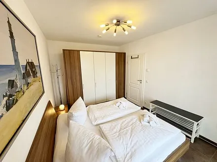 Schlafbereich mit Doppelbett (1,80 m x 2,00 m), Nachttischkonsolen und Kleiderschrank