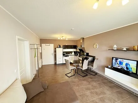 Wohnbereich mit Schlafsofa (Ausziehfunktion 1,30m x 2,00m für 2 Personen), kleiner Couchtisch, Leselampe, TV-Board mit Smart-TV, Receiver, DVD/Blu-Ray-Player und Ministereoanlage