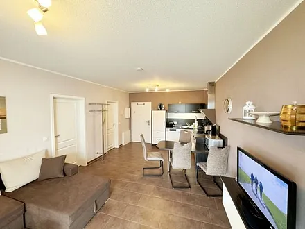 Wohnbereich mit Schlafsofa (Ausziehfunktion 1,30m x 2,00m für 2 Personen), kleiner Couchtisch, Leselampe, TV-Board mit Smart-TV, Receiver, DVD/Blu-Ray-Player und Ministereoanlage