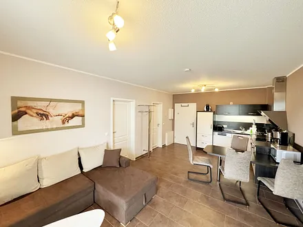 Wohnbereich mit Schlafsofa (Ausziehfunktion 1,30m x 2,00m für 2 Personen), kleiner Couchtisch, Leselampe, TV-Board mit Smart-TV, Receiver, DVD/Blu-Ray-Player und Ministereoanlage