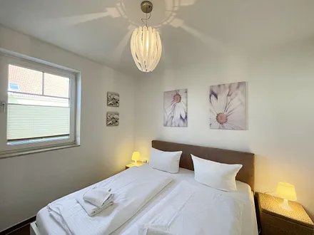 Schlafbereich mit Doppelbett (1,80 m x 2,00 m mit H2/H3 Matratzen) sowie verstellbare Lattenroste, Nachttischkonsolen und Kleiderschrank