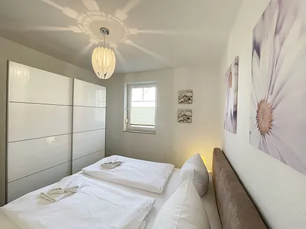 Schlafbereich mit Doppelbett (1,80 m x 2,00 m mit H2/H3 Matratzen) sowie verstellbare Lattenroste, Nachttischkonsolen und Kleiderschrank