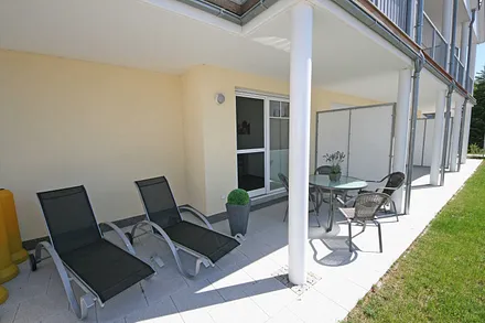 Terrasse mit Bestuhlung und Sonnenliegen