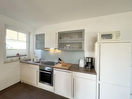 Küchenzeile mit Cerankochfeld, Backofen, Dunstabzugshaube, Kühlschrank mit Gefrierfach, Spülmaschine, Kaffeemaschine, Mikrowelle, Wasserkocher, Toaster und diverse Küchenutensilien