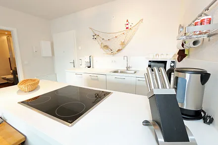 Küchenbereich mit Cerankochfeld, Backofen, Geschirrspüler, Kühlschrank, Kaffeemaschine, Mikrowelle, Wasserkocher, Mixer, Toaster und umfangreiche Küchenausstattung