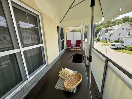 12 m² großer überdachter, bestuhlter Balkon (Süd/West) mit Sonnenschirm (transparente Balkonverkleidung)