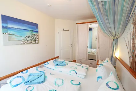 Schlafzimmer mit Doppelbett (1,80 m x 2,00 m), 7 Zonen-Kaltschaummatratzen, verstellbaren Lattenrosten, Nachttischablagen, Insektenschutzgitter, Verdunkelungsrollo und geräumiger Kleiderschrank