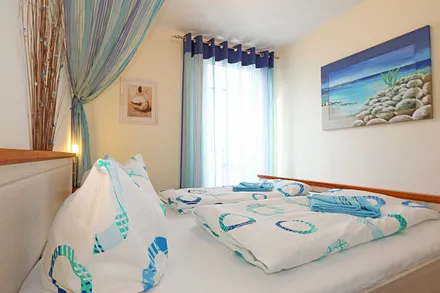 Schlafzimmer mit Doppelbett (1,80 m x 2,00 m), 7 Zonen-Kaltschaummatratzen, verstellbaren Lattenrosten, Nachttischablagen, Insektenschutzgitter, Verdunkelungsrollo und geräumiger Kleiderschrank