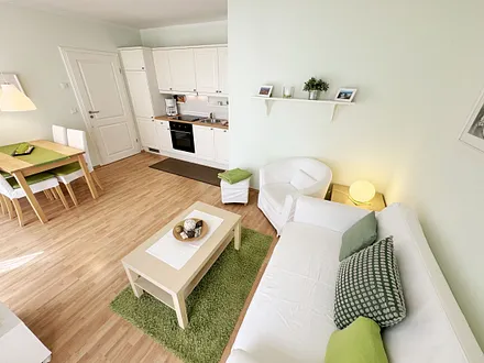 Wohnbereich mit einer Couch (Aufbettungsmöglichkeit für 3. Person – 1,20 m x 1,96 m), einen Sessel, Couchtisch, Leselampe, LED-TV und eine Mini-Stereoanlage mit CD und DVD-Player 