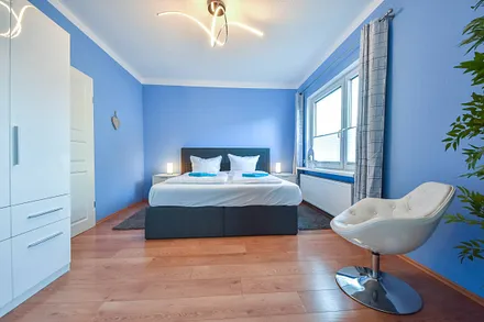 Hauptschlafzimmer mit Boxspringbett und Clubsessel