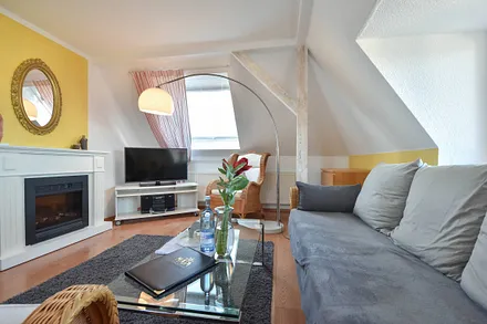 Wohnbereich mit Flachbild TV und Elektrokamin