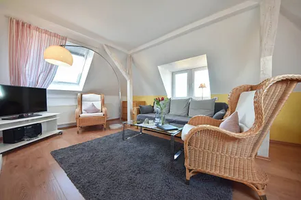 Wohnbereich mit Couch und gemütlichen Korbsesseln