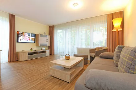Wohnzimmer mit Couch (Aufbettung für 3./4. Person, 1,50 m  x 2,00 m), Couchtisch, Leselampe, Smart-TV, Radio mit CD-Player