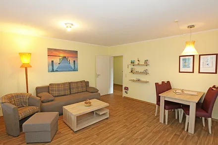 Wohnzimmer mit Couch (Aufbettung für 3./4. Person, 1,50 m  x 2,00 m), Couchtisch, Leselampe, Smart-TV, Radio mit CD-Player