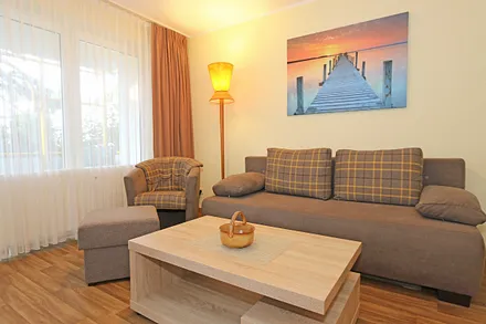 Wohnzimmer mit Couch (Aufbettung für 3./4. Person, 1,50 m  x 2,00 m), Couchtisch, Leselampe, Smart-TV, Radio mit CD-Player