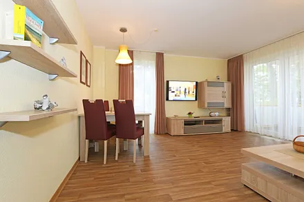 Wohnzimmer mit Couch (Aufbettung für 3./4. Person, 1,50 m  x 2,00 m), Couchtisch, Leselampe, Smart-TV, Radio mit CD-Player