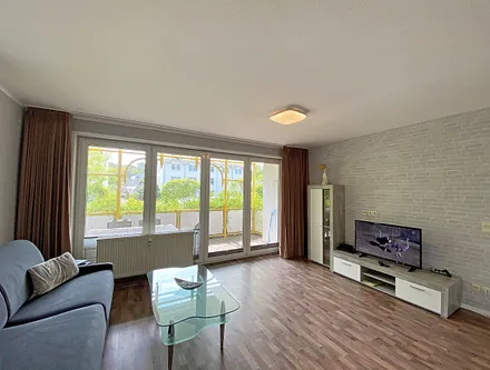 Wohnzimmer mit Schlafcouch (Aufbettung 3./4. Person, 1,60 m x 2,00 m), Sessel, TV sowie Blu-Ray-Player