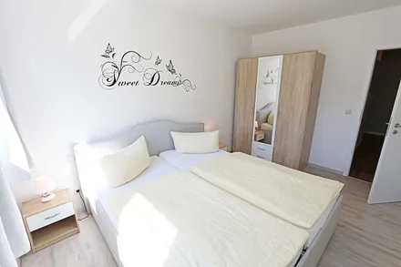 Schlafzimmer mit Doppelbett und Kleiderschrank