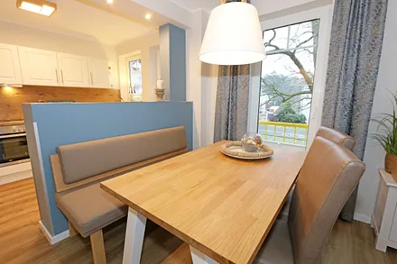 angrenzender Essbereich mit Tisch, Stühlen und einer Sitzbank