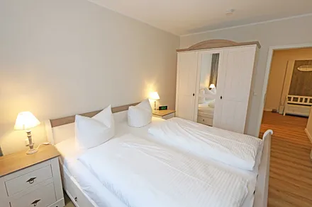 Schlafzimmer mit Doppelbett (1,80 m x 2,00 m), Nachttischablagen, Kleiderablage sowie einem 3- türigen Kleiderschrank