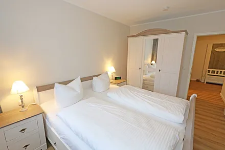 Schlafzimmer mit Doppelbett und Kleiderschrank