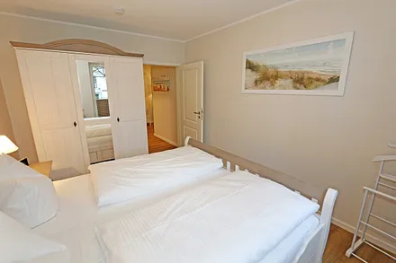 Schlafzimmer mit Doppelbett (1,80 m x 2,00 m), Nachttischablagen, Kleiderablage sowie einem 3- türigen Kleiderschrank